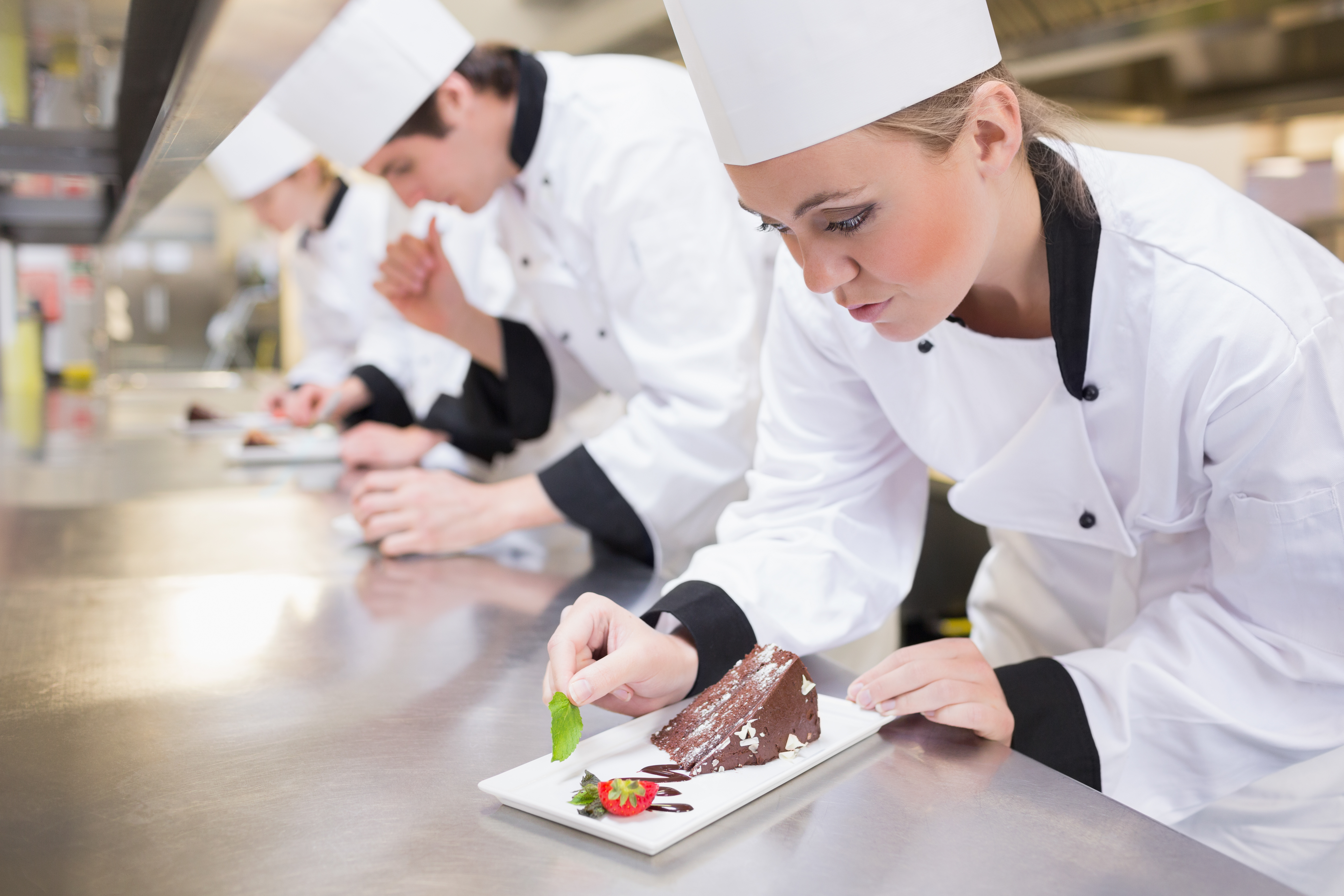 chef-039-s-team-garnishing-slices-cake