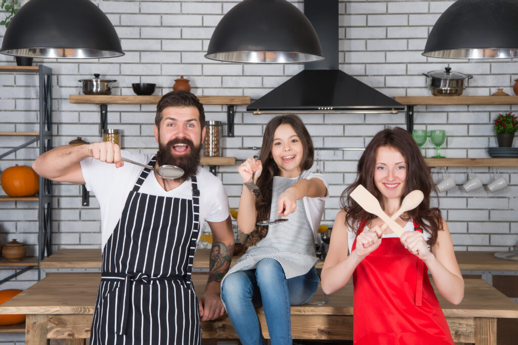 family-parents-daughter-cooking-food-together-kitchen-team-concept