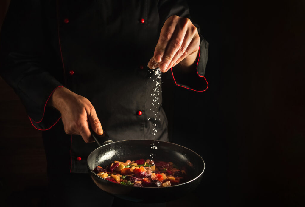 professional-chef-adds-salt-steaming-hot-pan
